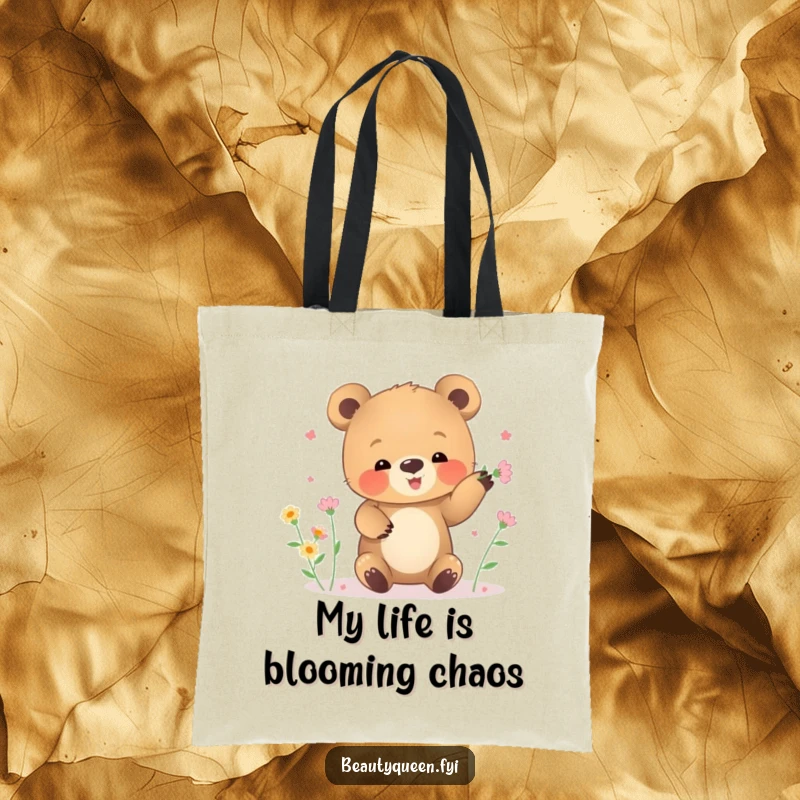 Funny tote bag with a small bear cub clumsily juggling tiny blooming flowers.